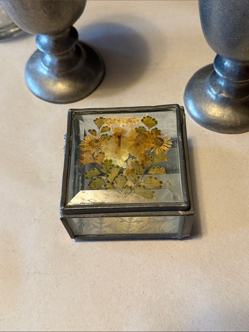Vintage trinket box with metal edges and dried flowers on top. Mirror bottom.